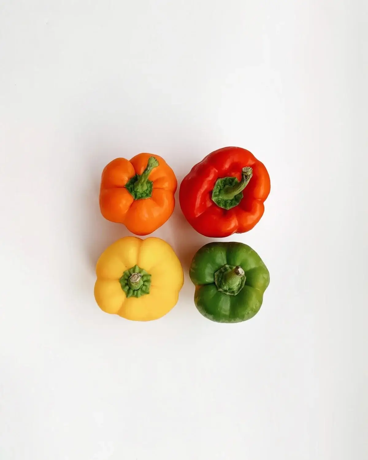 4 capsicums on white surface